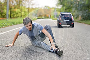 Hit and run concept. Injured man on road in front of a car