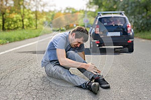 Hit and run concept. Injured man on road in front of a car