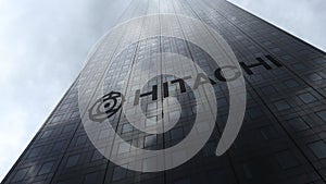 Hitachi logo on a skyscraper facade reflecting clouds. Editorial 3D rendering
