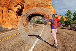 Hitch-hiking girl with rucksack near Red canyon