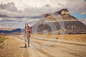 Hitchhiker woman walking on a road in USA