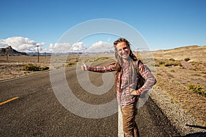 Hitchhiker woman walking on a road in USA