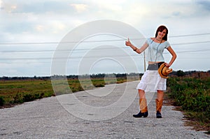 Hitchhiking country girl on rural road