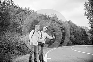 Hitchhiking gesture. Begin great adventure in your life with hitchhiking. Company friends travelers hitchhiking at road