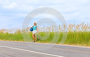 Hitchhiking girl votes on road photo