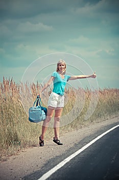 Hitchhiking girl votes on road photo