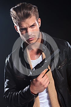 Hitman in leather clothes holding a big gun in his hand photo