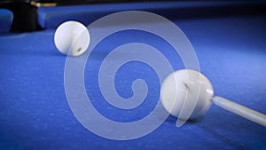 Hitting the cue ball number 7 on a blue billiard ball. The billiard ball hits the pocket