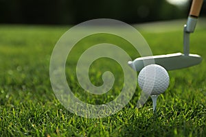 Hitting golf ball with club on green course, closeup. Space for text
