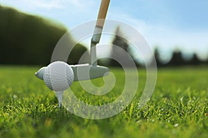 Hitting golf ball with club on green course, closeup. Space for text