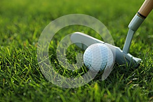 Hitting golf ball with club on green course, closeup. Space for text