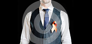 Hiv aids. Red ribbon in hiv world day isolated on dark background. Man holding awareness aids and cancer symbol. Health