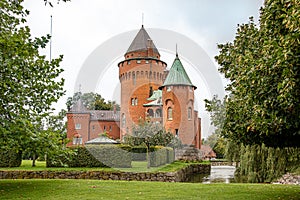 Hjularod is a romantic red castle with tall towers situated in a green park