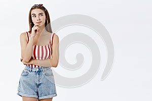 Hmmm need to think. Portrait of thoughtful creative and stylish young female model in striped pin-up top and shorts