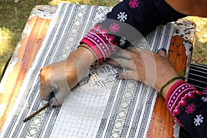 Hmong hilltribe writing candles to made traditional cloths