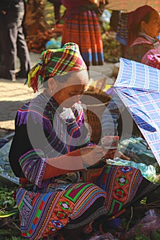 hmong woman counting money in Bac Ha market