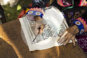 Hmong women painting batik using hot wax