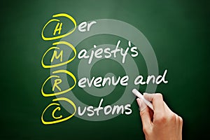 HMRC - Her Majesty`s Revenue and Customs acronym, business concept on blackboard