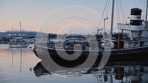 HMS Justice tug boat stern sits partially aground at low tide at sunrise