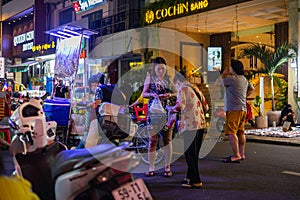 Ho Chi Minh City, Vietnam- November 9, 2022: Street vendor in Saigon sells his wares. Nightlife in the busy narrow streets of the