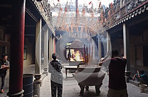 Ho Chi Minh City, Vietnam: visitors and worshipers in front of ritual fire in Thien Hau Pagoda in Cho Lon