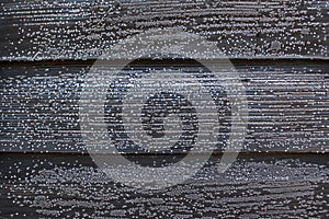 Hoarfrost on black wooden boards