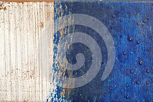 Hoarse, scratched and peeled surface with blue and white paint photo