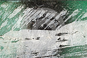 Hoarse, scratched, peeled surface with green, white and black pa