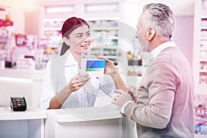 Hoary purchaser staying near a counter discussing his prescription