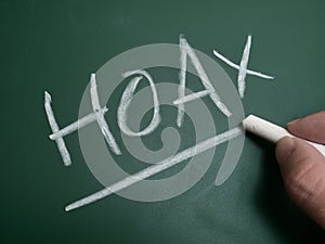 Hoax, text written on chalkboard, fake news gossip issue