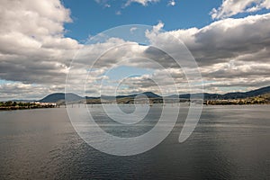 Hobart, Tasmania, Australia - December 13. 2009: Long shot at Tasman highway bridge over Derwent River with mountains under heavy