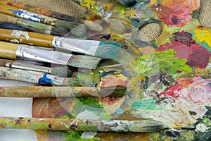 Hobbies, work, art and life in different colors on a palette with a brushes.Artist palette with a brush closeup.