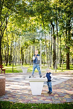 Hobby of Children, Boy and Girl Playing Chess. Funny little brother and sister playing outdoor chess in the park on a public site