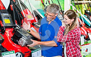 Hobby gardener couple in garden center looking for lawnmower