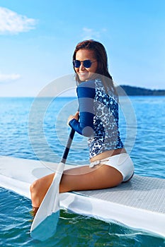 Hobby. Girl Paddling On Surfboard. Summer Travel.