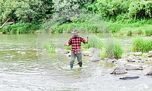 Hobby is Joy of time. summer weekend. Successful fly fishing. mature man fly fishing. man catching fish. bearded fisher