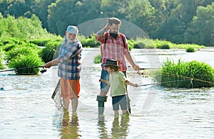 Hobby and sport activity. Men hobby. Summer weekend. Father teaching son how to fly-fish in river. Summer day. Anglers.