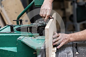 Hobby wood concept. Cropped photo of cabinetmaker handyman tradesman hands install wooden plank on woodworking machine make