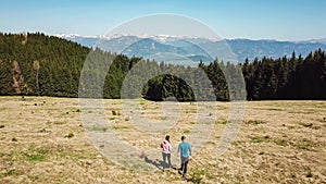 Hochanger - Hiker couple on golden alpine meadow of mount Hochanger, Bruck an der Mur, Lavanttal Alps, Styria, Austria