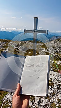 Hochschwab - Writing in summit book on top of mountain peak Hochwart in Hochschwab massif, Styria, Austria. Idyllic hiking trail