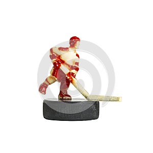 Hockey. The figure of a red toy hockey player is standing on the puck. Children`s hockey, a symbol of sports hockey. Isolated on