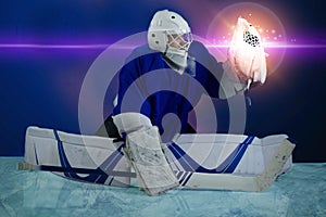 Hockey goalie kneels and holds the puck in the catcher.