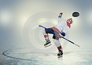 Hockey player falls down on ice photo
