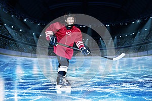 Hockey player with stick on the rink of ice arena