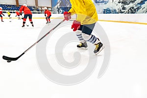 Hockey player in a yellow tank top and red gloves for people drives the puck. Training game, the object is blurred in dynamics