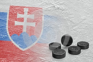 Hockey pucks and the image of the Slovak flag on ice