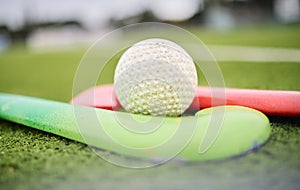 Hockey, stick and ball on a field for a game, training or exercise for sports. Closeup, ground and gear or equipment for