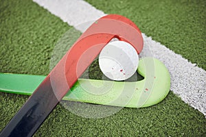 Hockey, stick and ball on green, field or pitch with sports equipment for game, competition or match on ground or floor