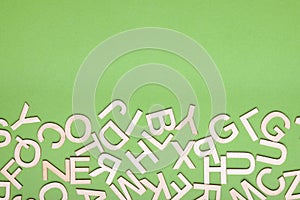 hodgepodge of wooden letters on green paper background