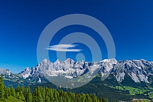 Hohe Dachstein mountain range in Austria with a soft white cloud